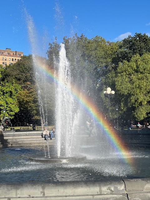 photo of fountain, with rainbow in the water spray
