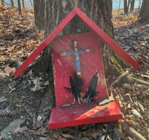 photograph of a bird feeder and shrine with a hand-painted crucifix